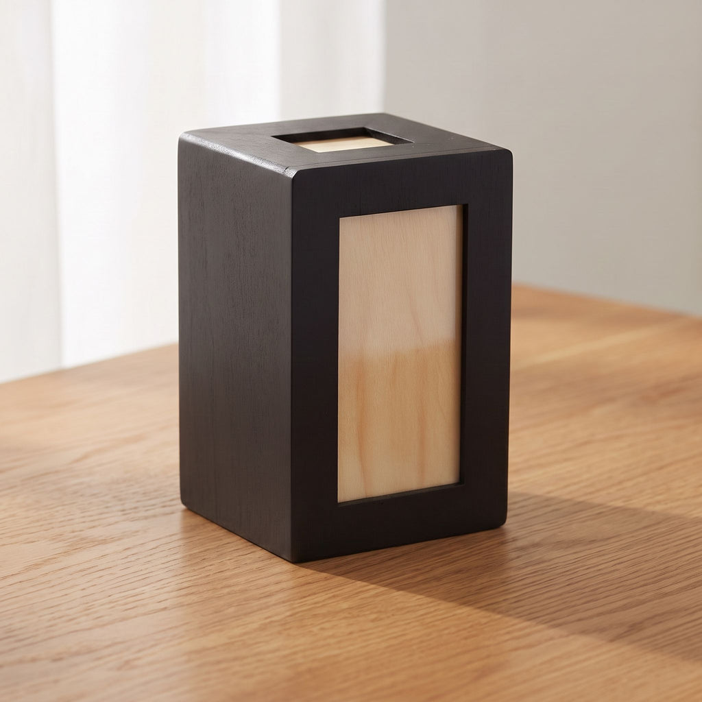 Close-up of wooden pet urn with black finish showing wood grain and craftsmanship, soft natural light emphasizing texture and dignity.