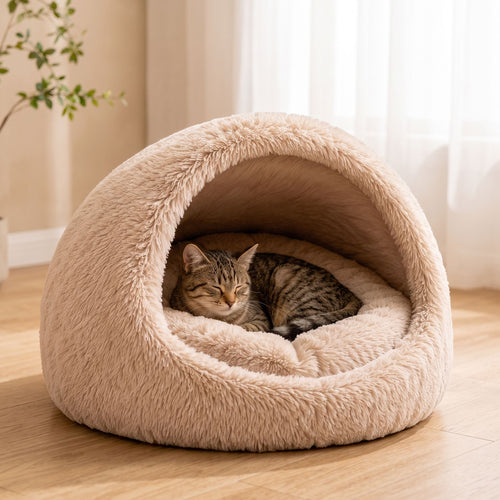 Tabby cat sleeping inside a cozy semi-enclosed plush pet bed on a hardwood floor.