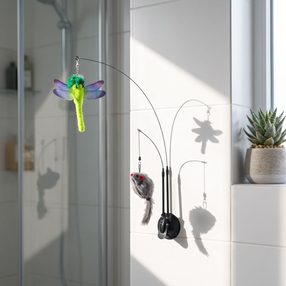 Side-angle view of the small Cat Sucker Teaser Toy adhered to a white tiled wall in a modern bathroom with natural light.