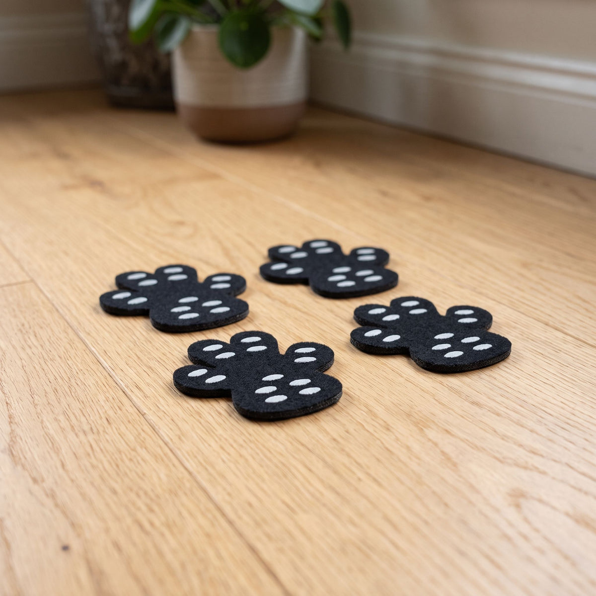 Close-up of small dog anti-slip pads showing textured grip pattern on a wooden floor.