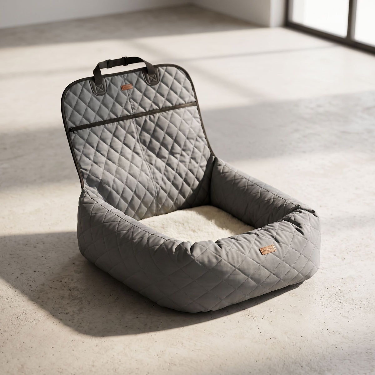 Pet car bed on minimalist studio floor emphasizing thickness and quilted design of cushion.